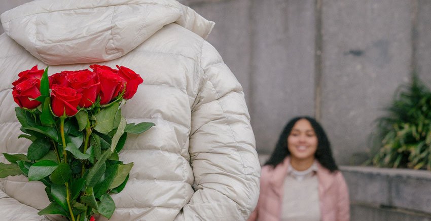 A boy suprising a girl with roses